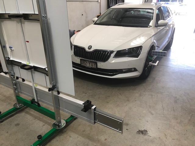 An ADAS calibration rig and target board set up in front of a Škoda at the Sunshine Coast Windscreens workshop in Buderim
