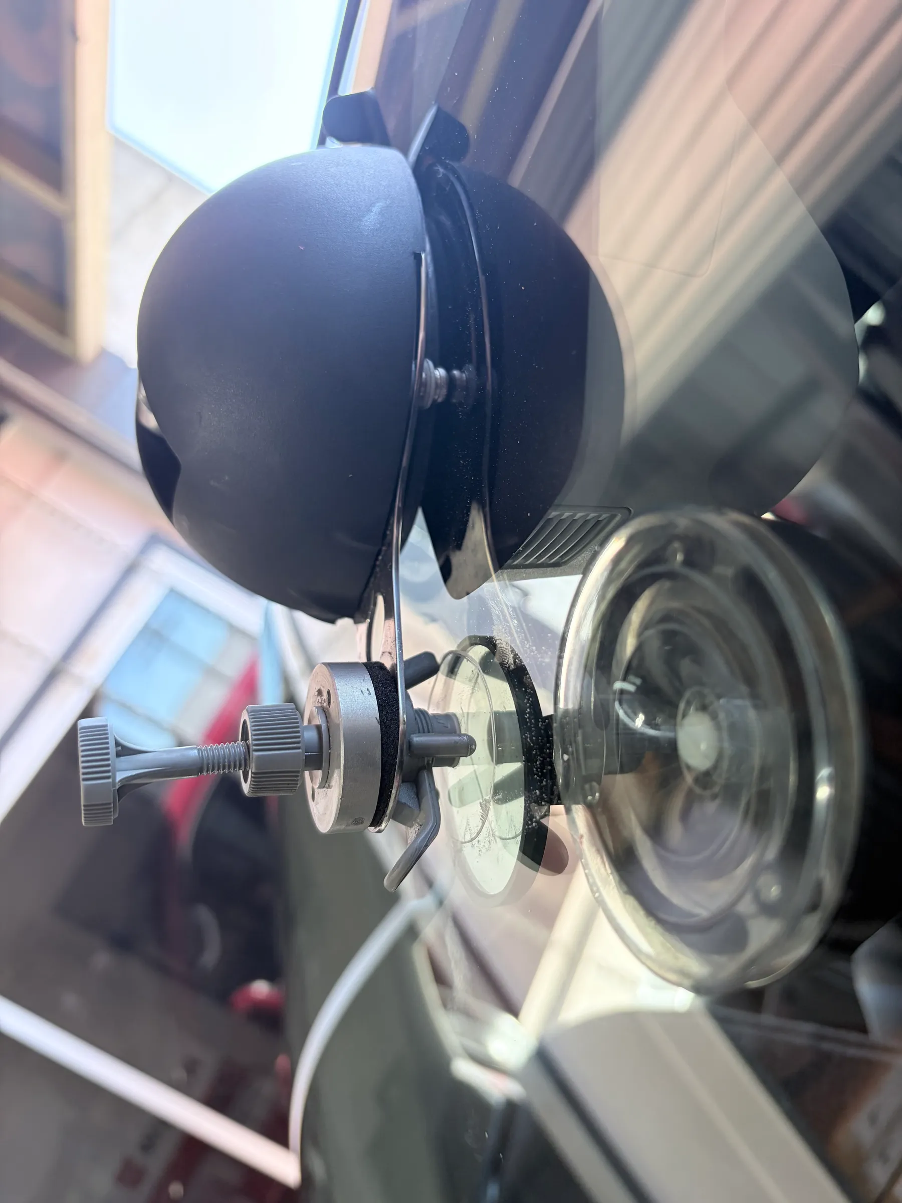 Windscreen chip repair Sunshine Coast — the resin injection bridge and UV curing lamp clamped over a stone chip