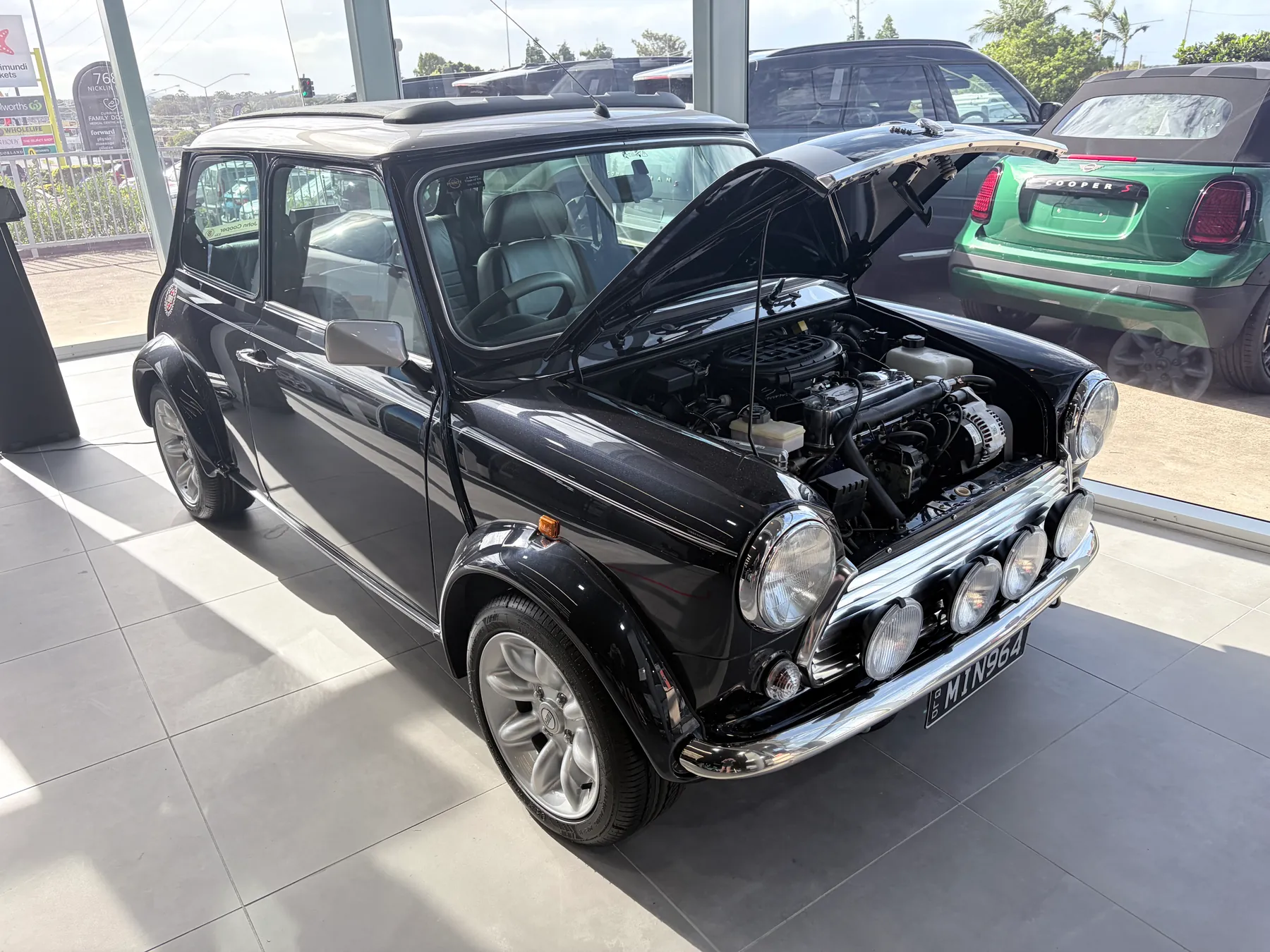 A classic black Mini Cooper in the workshop for glass work