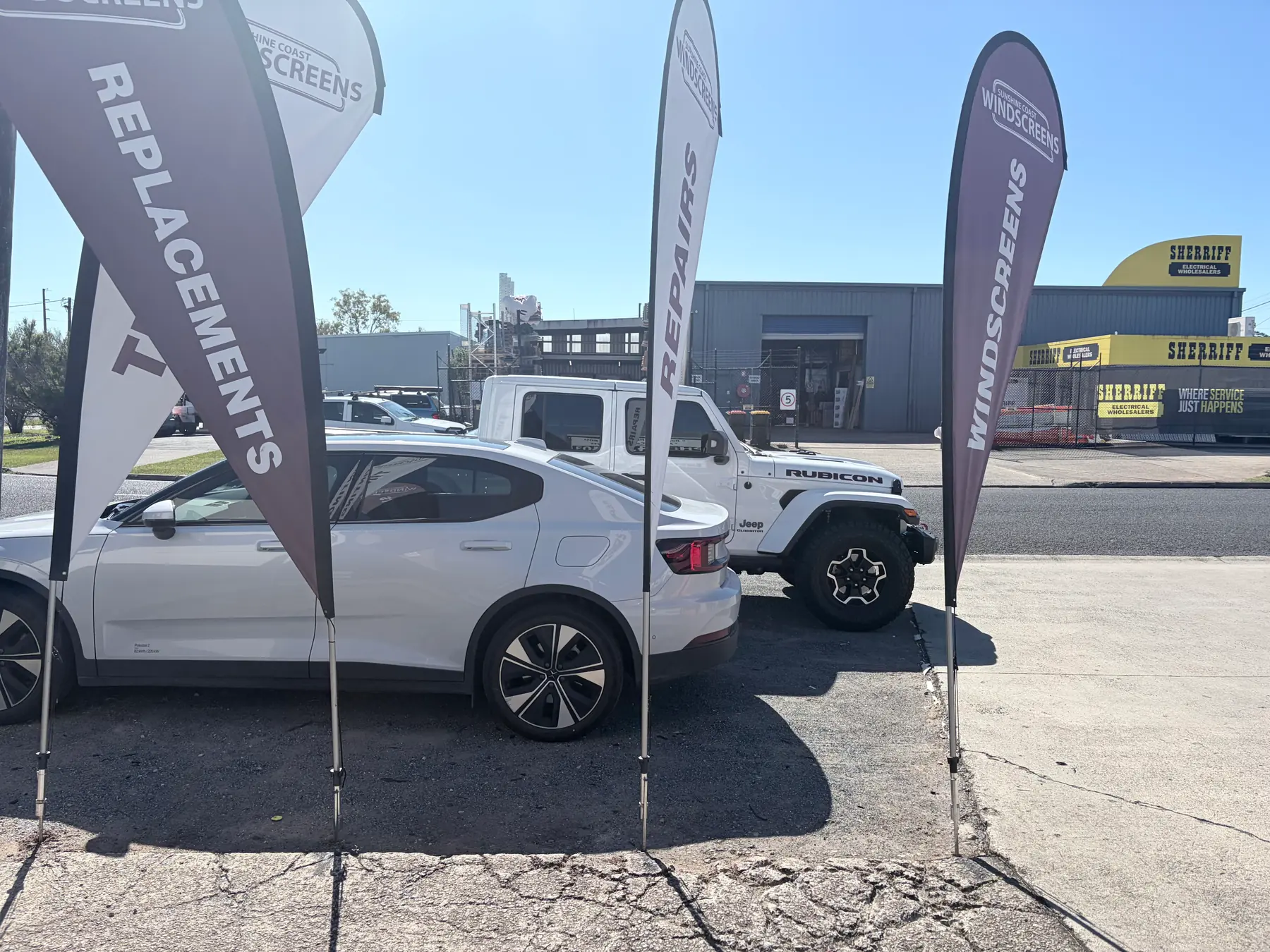 A Jeep 4WD and a Polestar EV outside the Sunshine Coast Windscreens shopfront